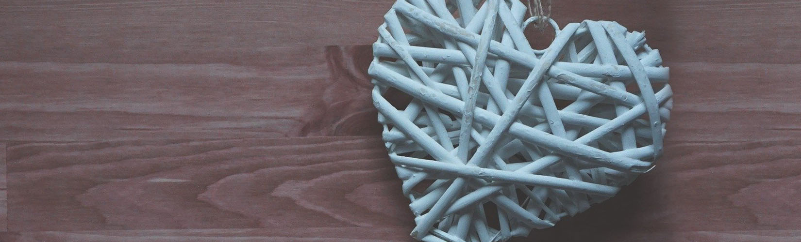 White woven heart on a wood surface
